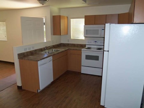 A kitchen with white appliances and wooden cabinets.