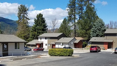 a group of houses with cars parked in a parking lot