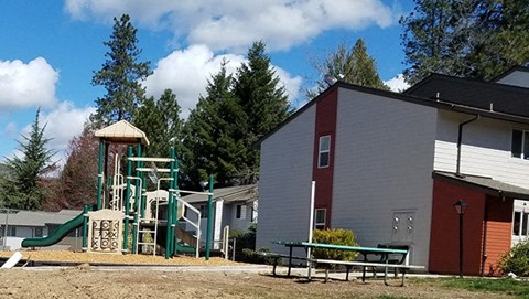 a playground in front of a building and a house
