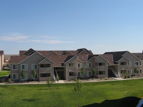 A row of houses with green lawns in front.