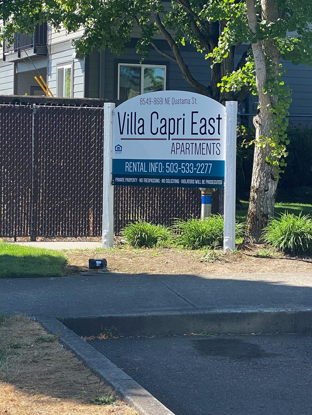a sign for villa capri east apartments in front of a fence