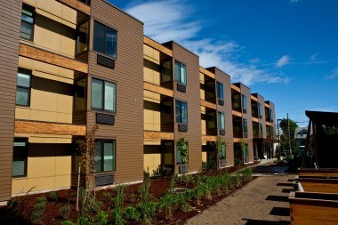 A row of modern apartment buildings with balconies and wooden accents.