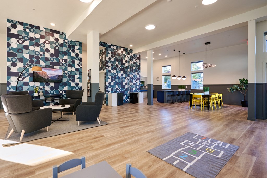 a large lobby with chairs and tables and a wall with a patterned wallpaper