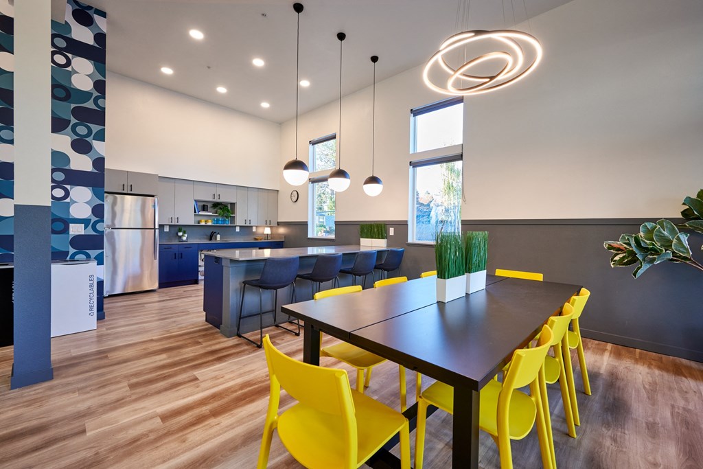 a dining room and kitchen with yellow chairs and a black table