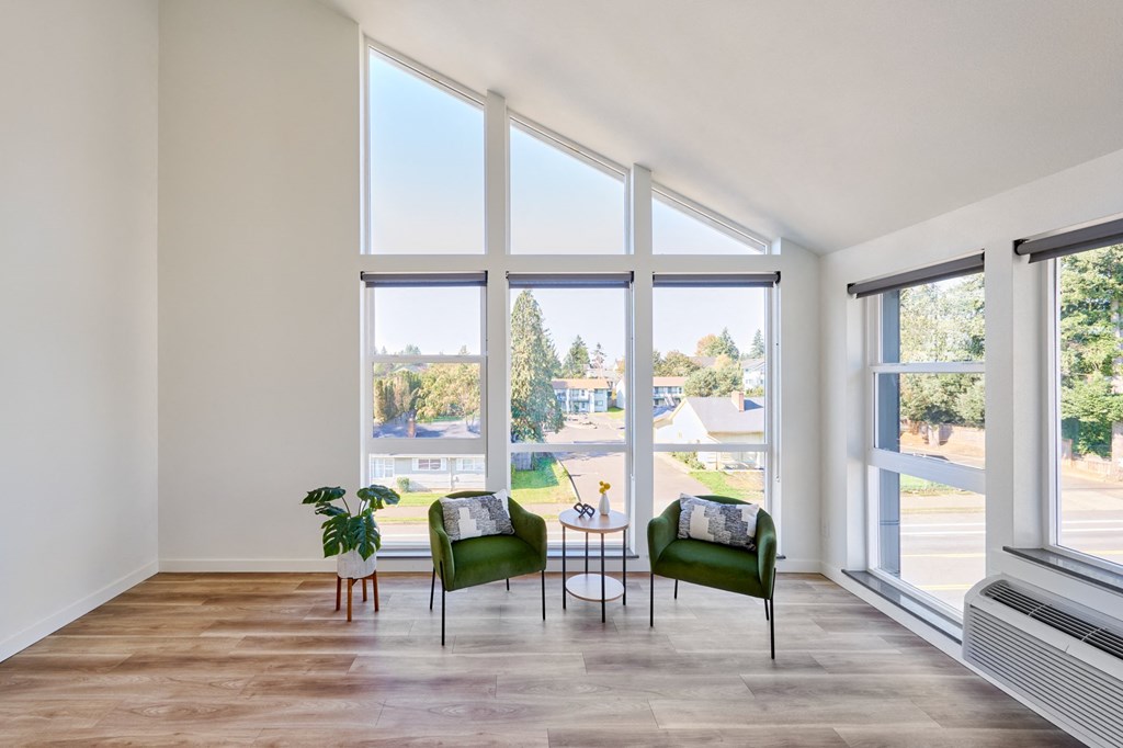 a living room with large windows and a table and chairs