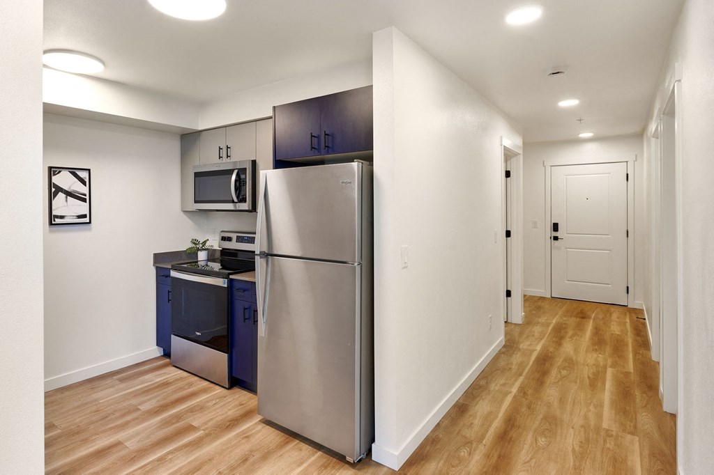 a renovated kitchen with stainless steel appliances and blue cabinets