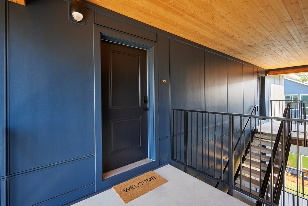 the stairway leading up to the top floor of a house with a blue door