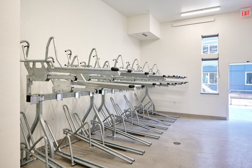 a row of metal chairs in a room with a wall of mirrors