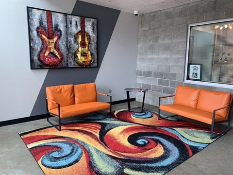 a living room with two orange chairs and a colorful rug