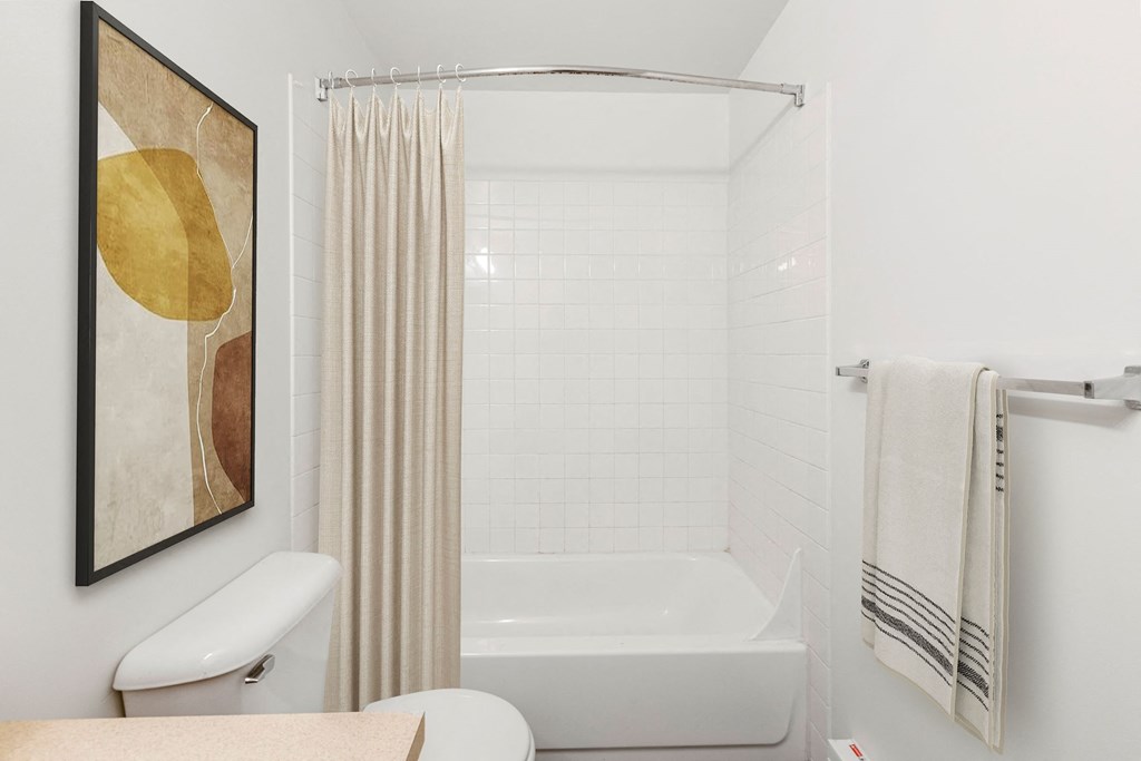a white bathroom with a tub and a shower curtain
