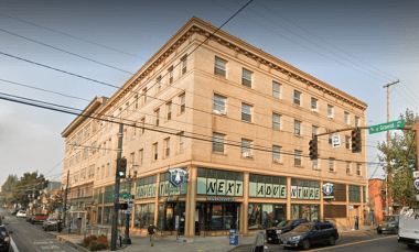 A street view of a building with the words "NEXT" and "LAUGH" on the front.