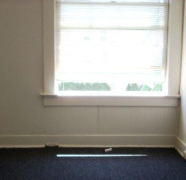 A room with a window and a blue carpet.