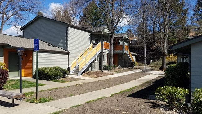 a sidewalk in front of a row of houses