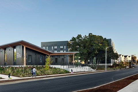 A modern building with a person walking in front of it.