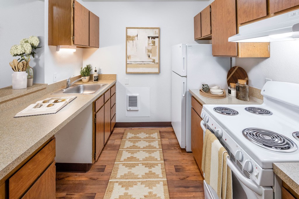 a kitchen with wooden cabinets and a white stove top oven