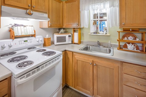 a kitchen with white appliances and wooden cabinets