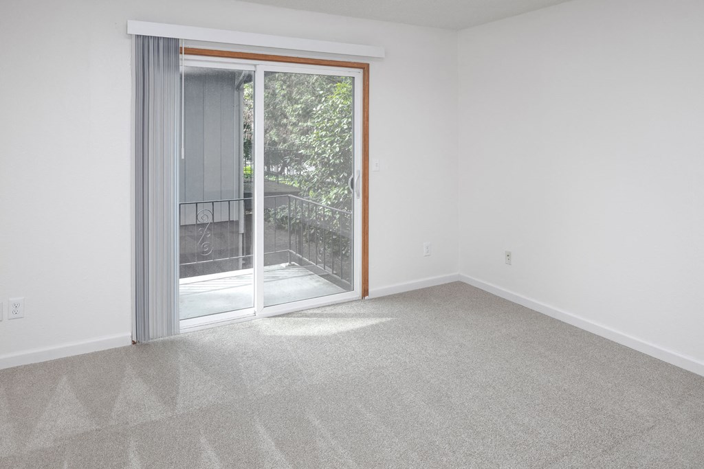 a bedroom with a sliding glass door and carpet
