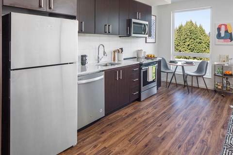 a kitchen with stainless steel appliances and a table with chairs