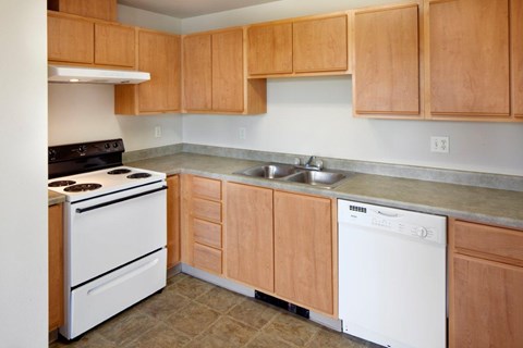 A kitchen with wooden cabinets and white appliances.