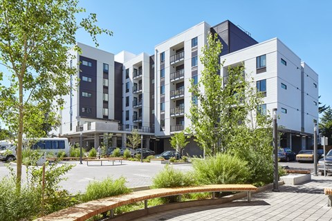 A modern building with a parking lot in front.