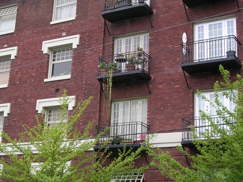 A red brick building with white trim and black balconies.