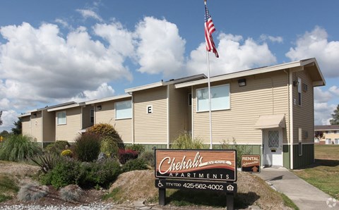 A building with a sign that says "Chehalis Apartments" in front of it.