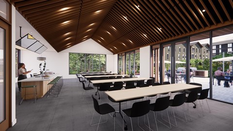 A room with tables and chairs and a person sitting at a table.
