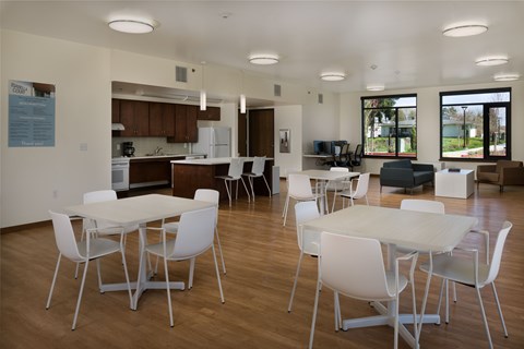 A kitchen with white chairs and a white table.