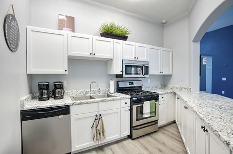 A kitchen with white cabinets and a black dishwasher.