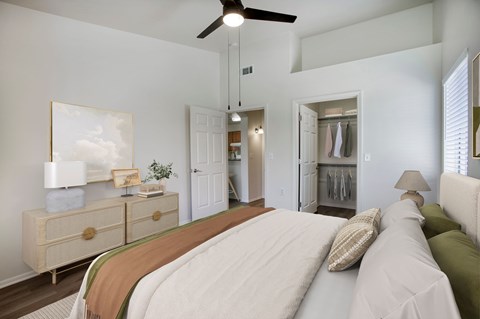 A bedroom with a large bed and a ceiling fan.