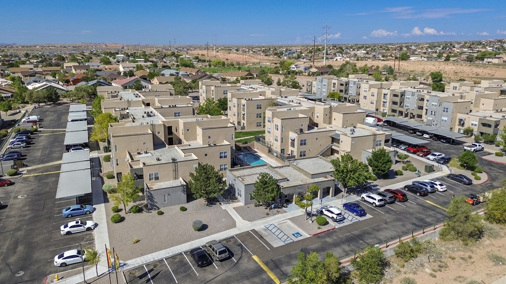 A parking lot with cars and a building in the background.