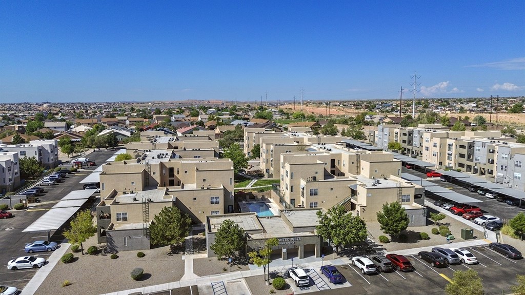A parking lot with cars and a building in the background.