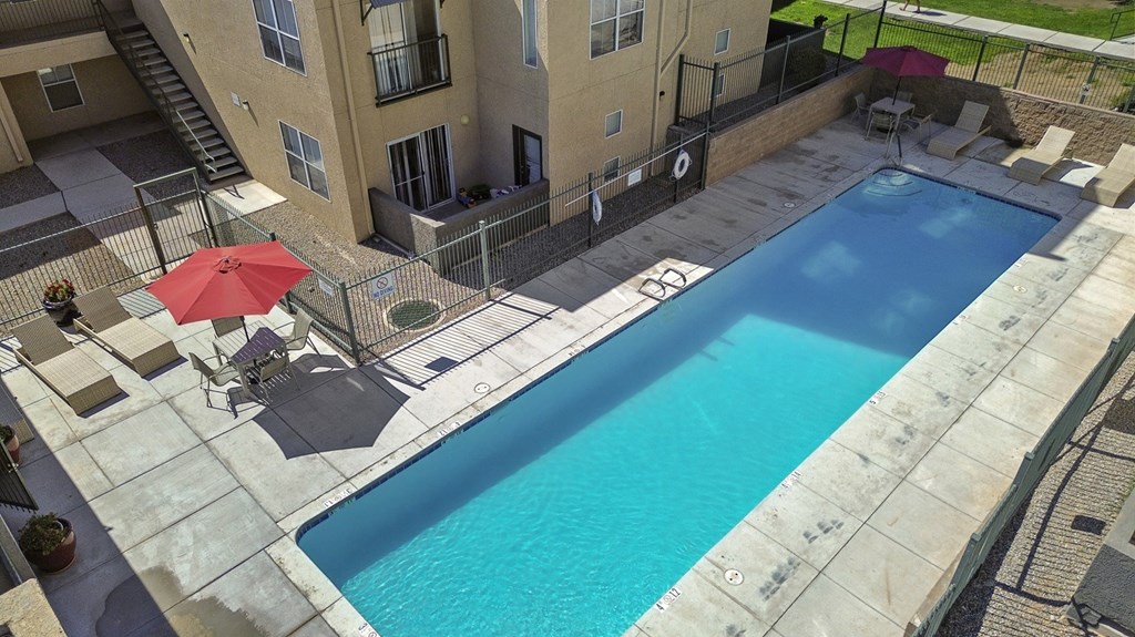 A red umbrella is next to a pool.
