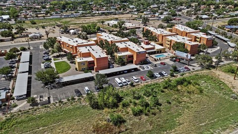 An aerial view of a parking lot with cars and a building complex.
