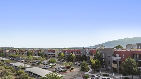 A parking lot is in the foreground of a residential area.