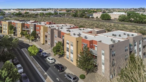 A street view of a residential area with cars and buildings.