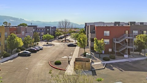 A parking lot with cars and apartment buildings in the background.