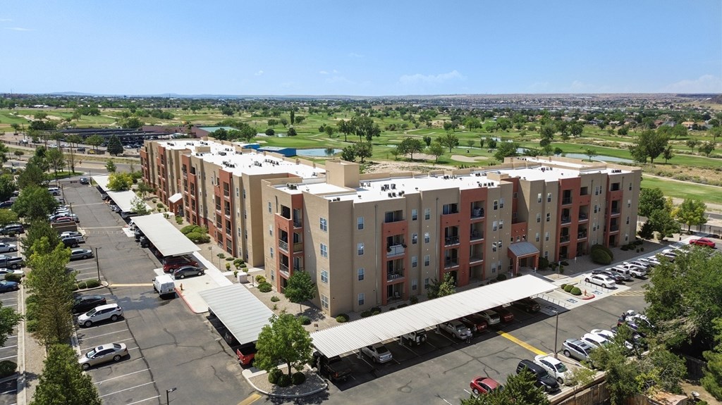 A large apartment complex with a parking lot in front.