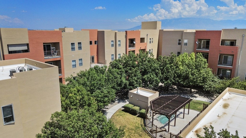 Apartment complex with a pool and trees.