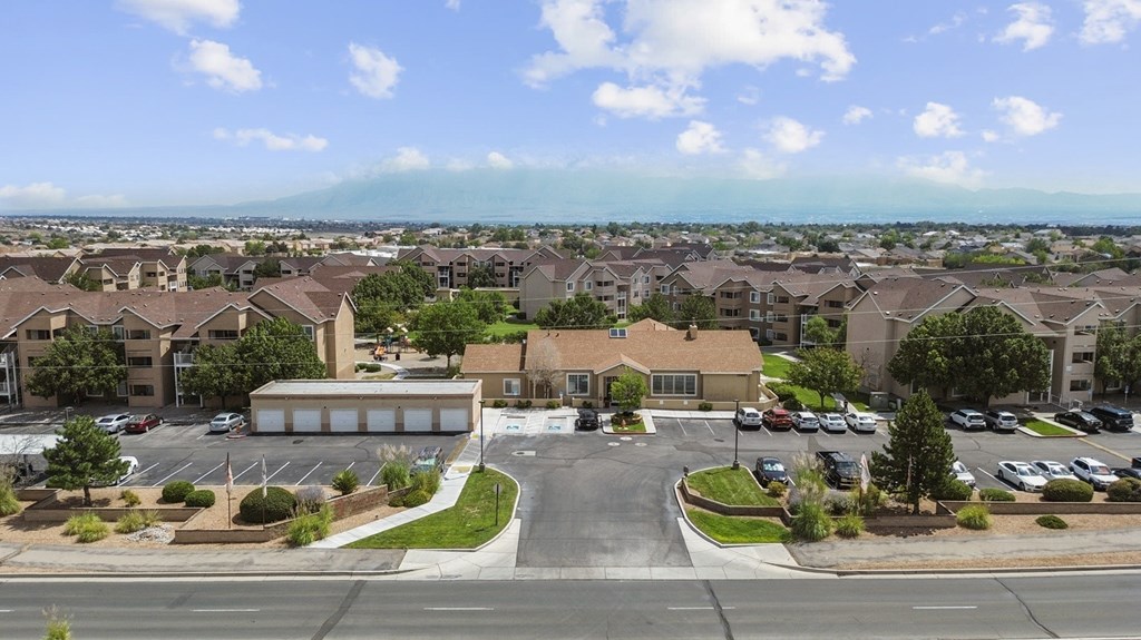 A view of a residential area with houses and a parking lot.