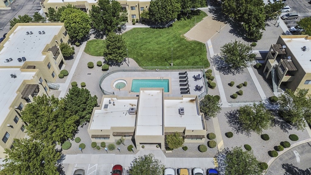 A bird's eye view of a residential area with a swimming pool.
