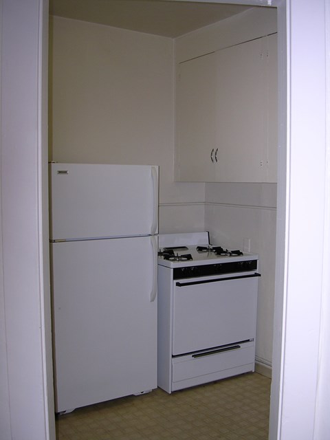 A white refrigerator and stove in a small kitchen.