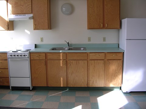 A kitchen with a white refrigerator and a white stove.