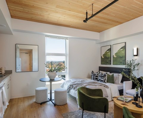 A modern bedroom with a large bed and a green armchair.