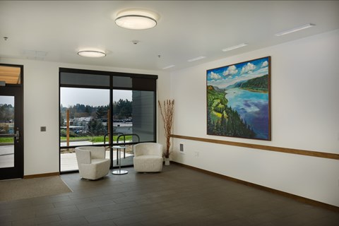 A large painting hangs on the wall of a spacious room.