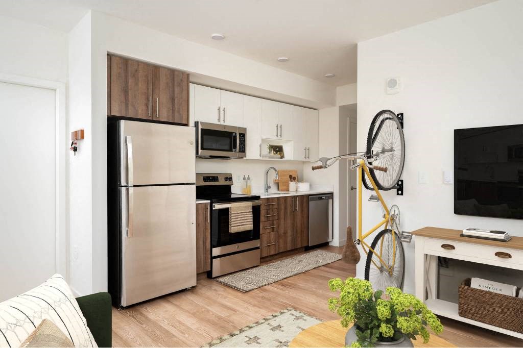 a kitchen with stainless steel appliances and a bike in a living room