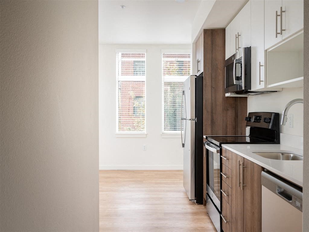 an empty kitchen with a sink and a refrigerator