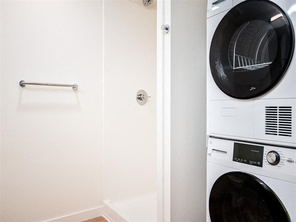 a washer and dryer in a laundry room with a white wall and a