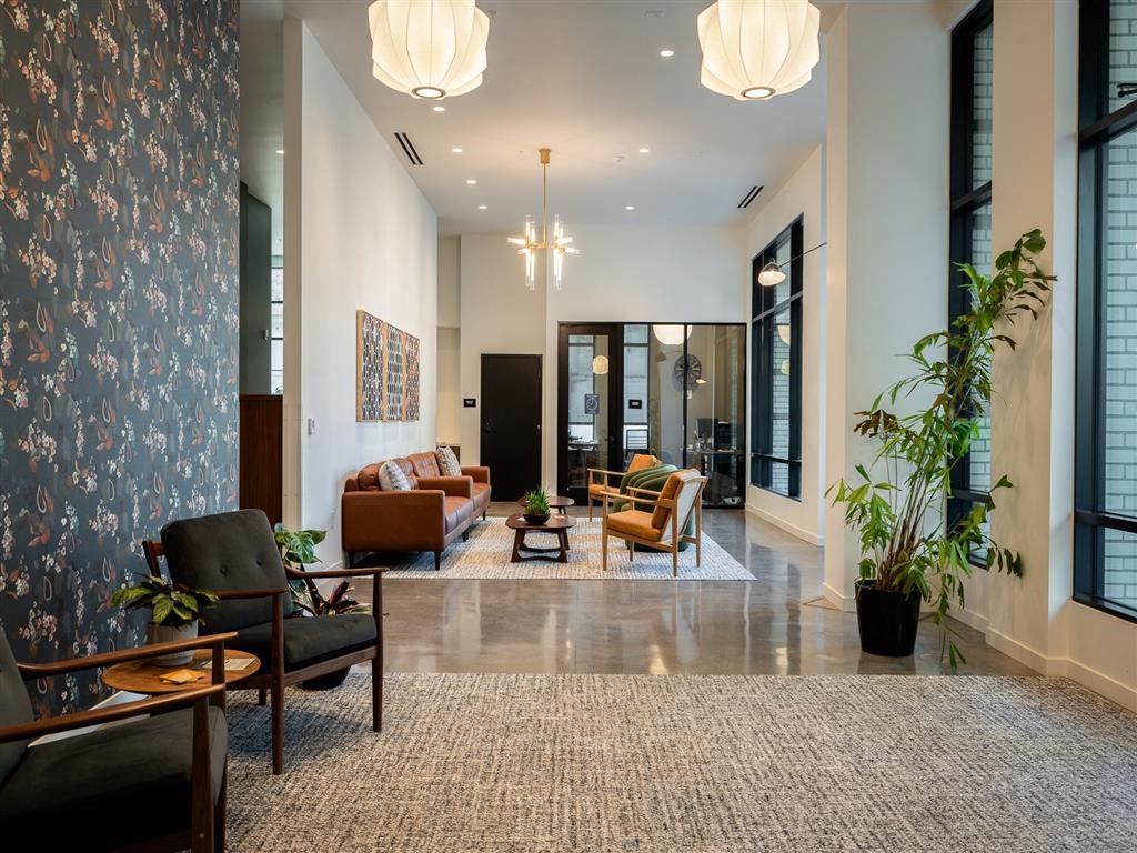 a living room with couches and chairs and a large rug