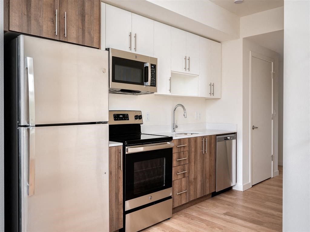 a kitchen with white cabinets and stainless steel appliances and a refrigerator